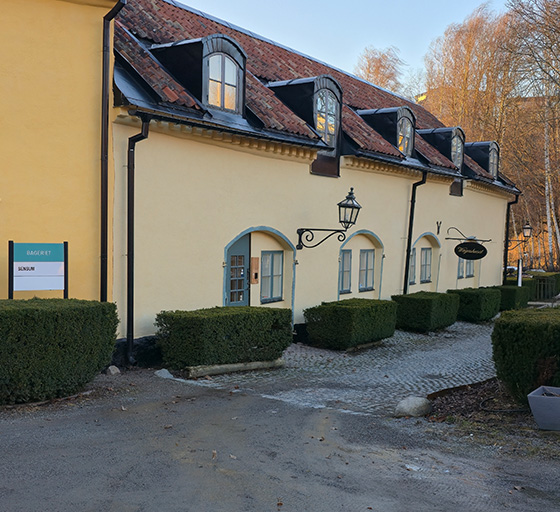 An old yellow building with red/brown roof depicting the Emvico office