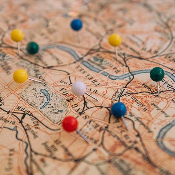 An old map with colored pins stuck to it